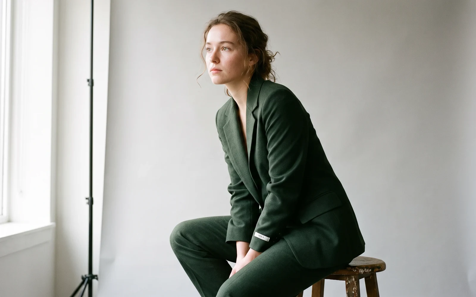 Editorial studio portrait with fabric texture and a readable size label